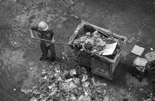 Company representative examining waste containers in Upminster